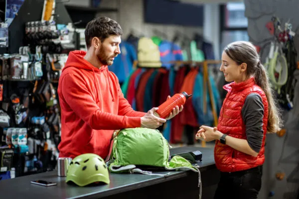 Woman with salesperson at the counter of sports shop